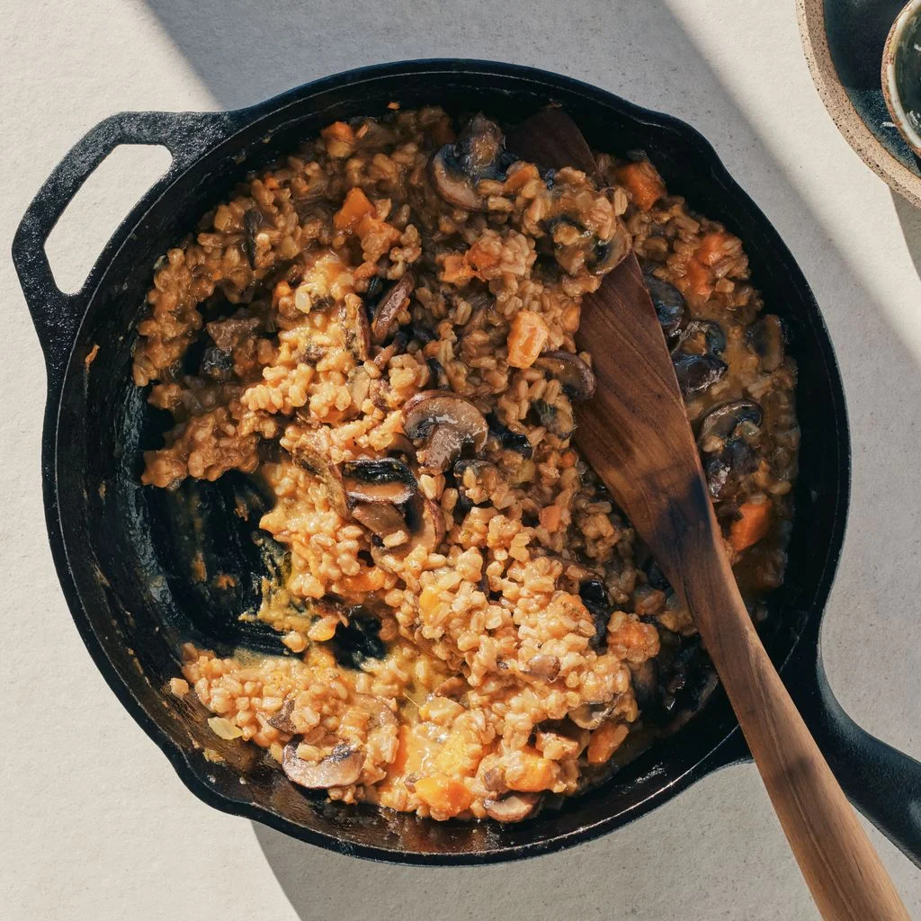 Farro baby bella mushrooms and chopped sweet potatoes simmered in vegetable broth in a castiron skillet and served...