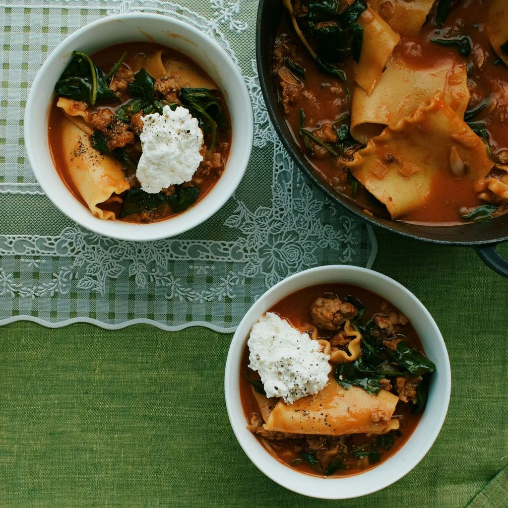 Lasagna sausage spinach and ricotta in small bowls with a Dutch oven.