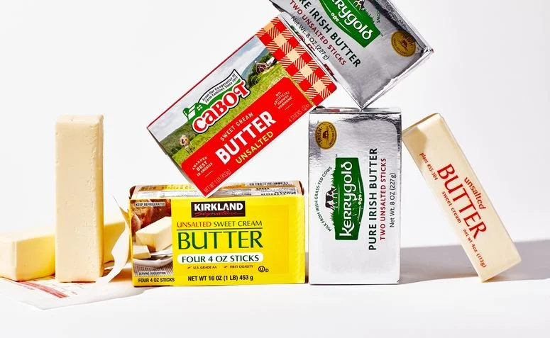 Three different types of butter leaning on each other isolated on white.