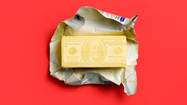 Photo illustration of a bar of butter with a one hundred bill marked on it. 