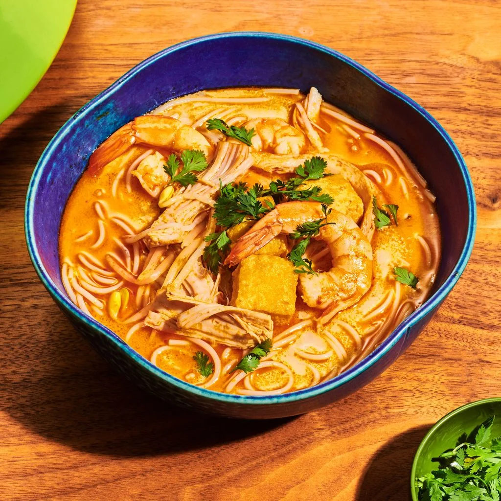 Turkey laska noodle soup in a blue bowl