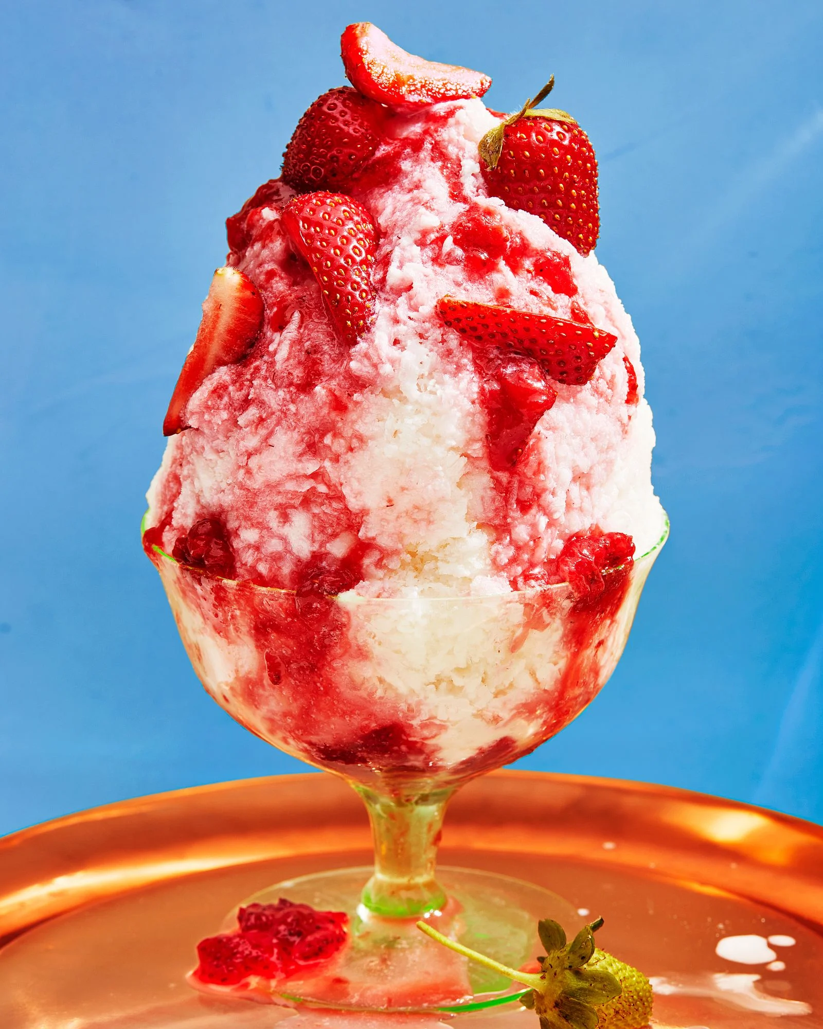 a cup of shaved milk with strawberries on a blue background